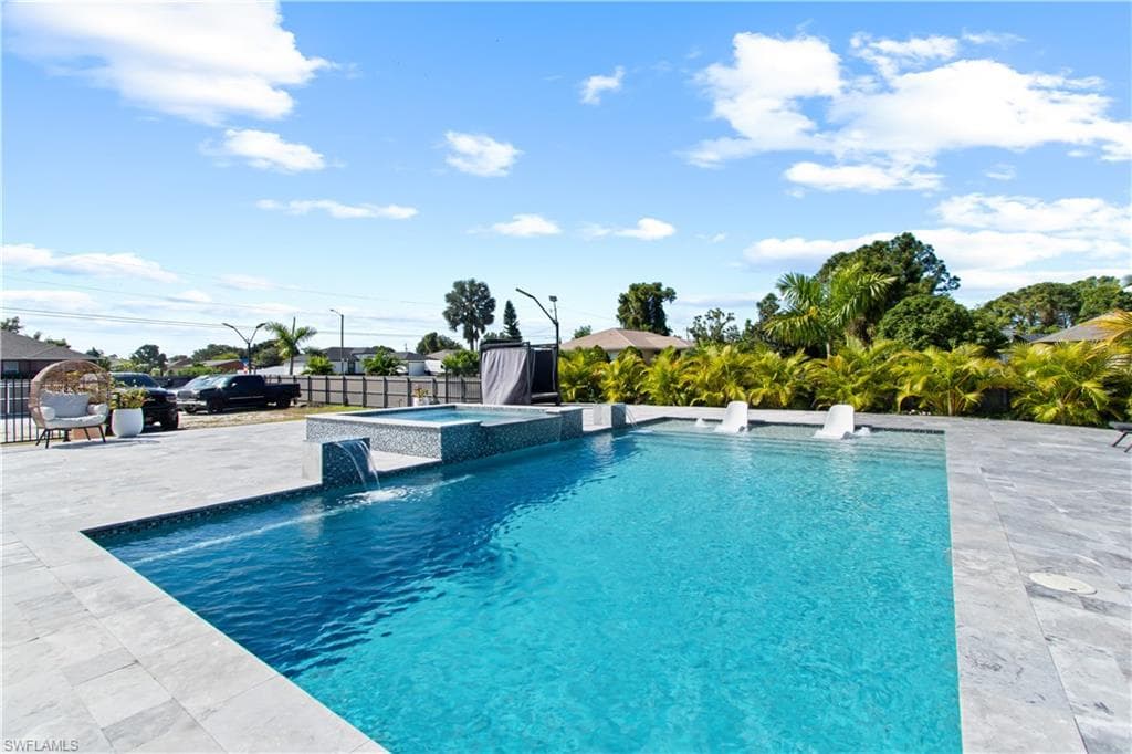 View of pool with a fenced backyard, a patio area, and a pool with connected hot tub