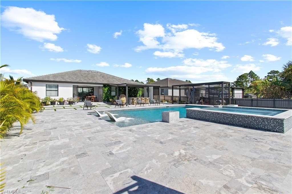 View of swimming pool with a patio area and a pool with connected hot tub