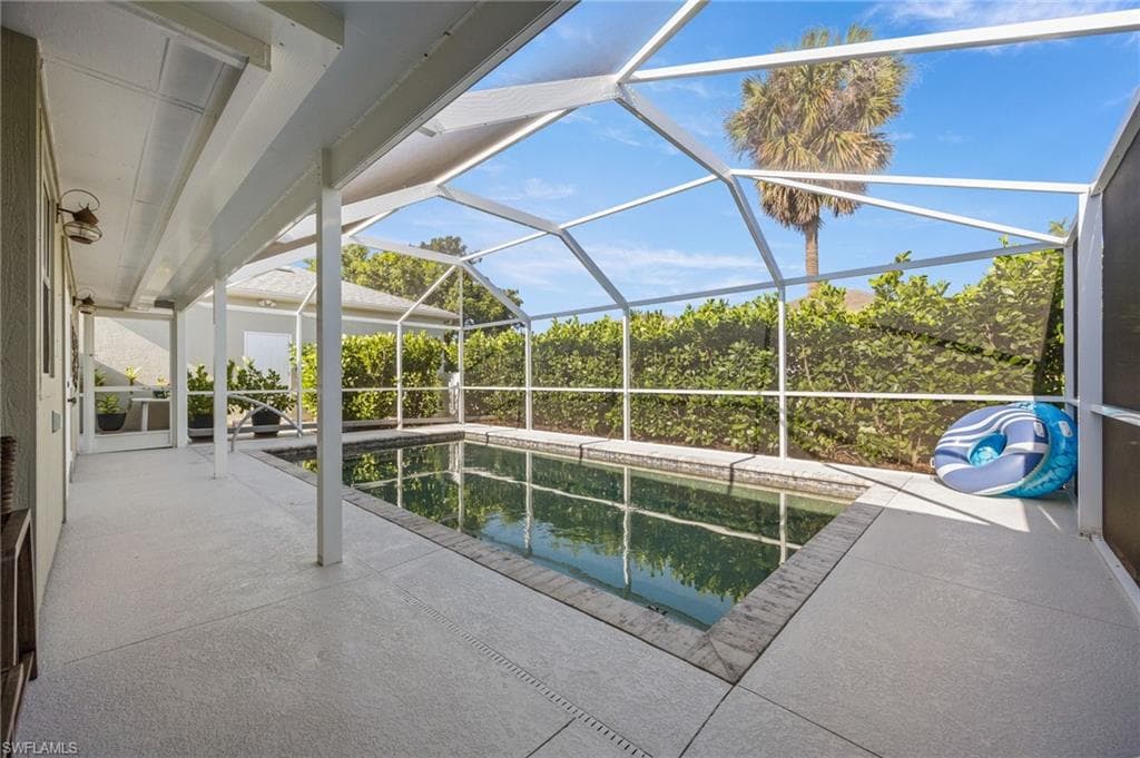 Swimming pool featuring a patio, a lanai, and a sunroom