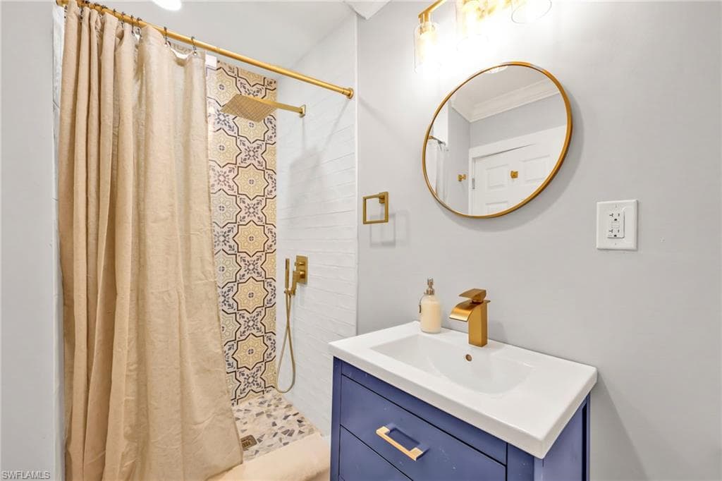 Bathroom with vanity, a stall shower, and ornamental molding