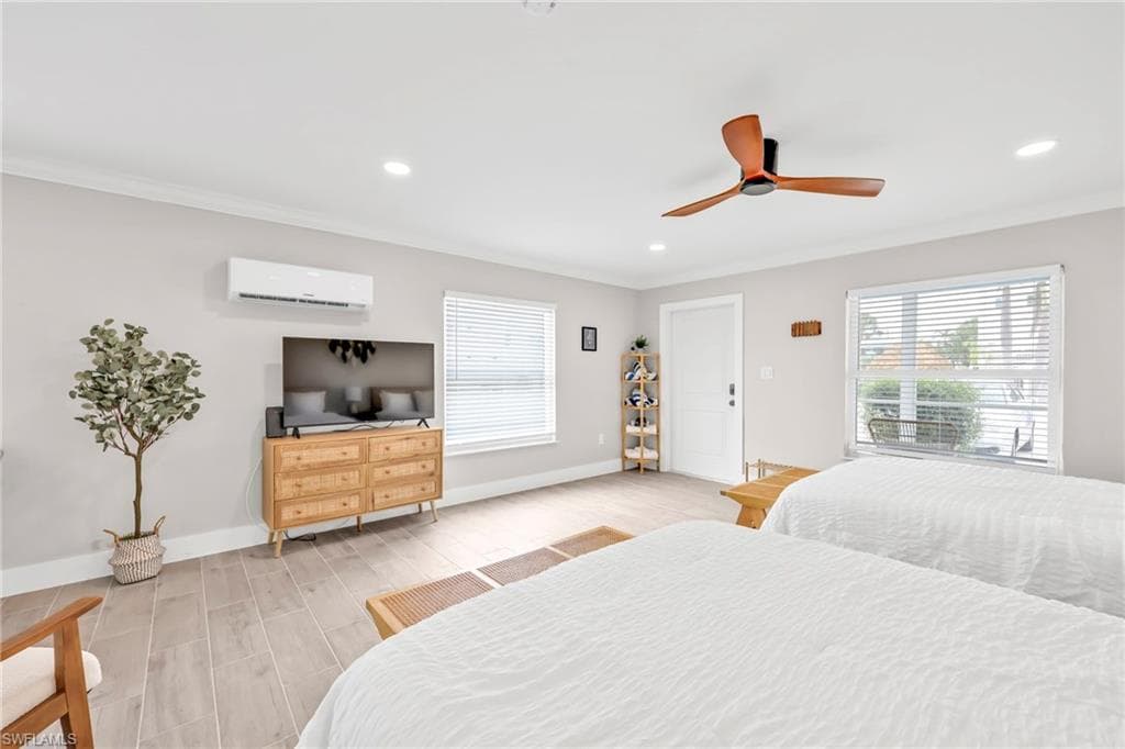 Bedroom featuring wood tiled floors, crown molding, ceiling fan, recessed lighting, and a wall mounted air conditioner