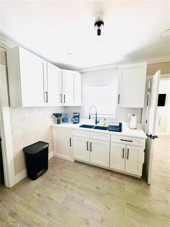 Kitchen featuring white cabinets, light countertops, and wood tiled floors