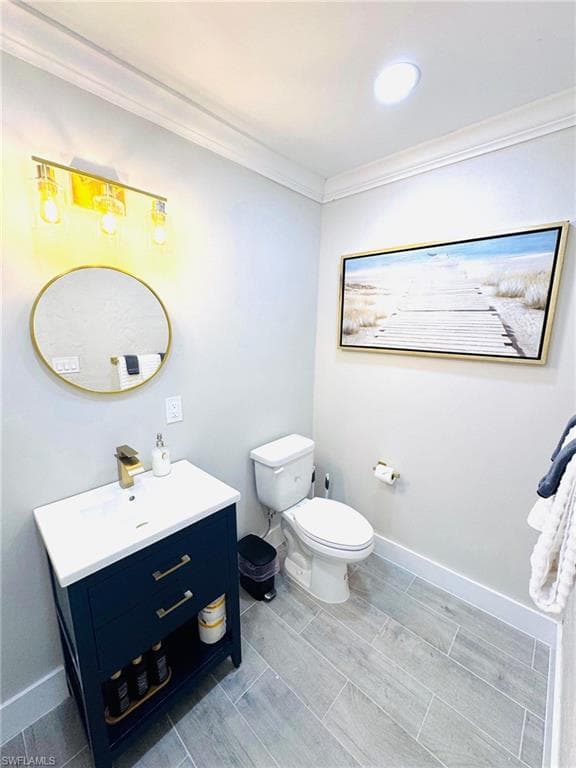 Half bathroom featuring ornamental molding, vanity, and wood tiled floors