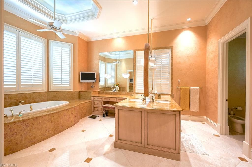 Primary Bathroom with vanity, ornamental molding, a bath, light tile patterned floors, and a bidet