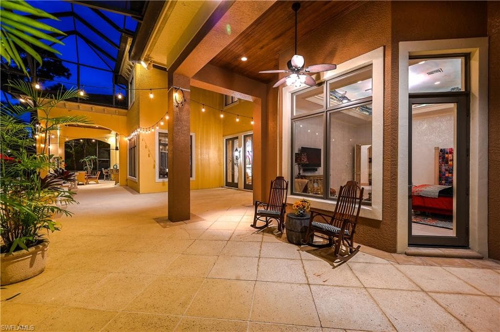 Patio at twilight featuring a ceiling fan, a patio area, and a lanai