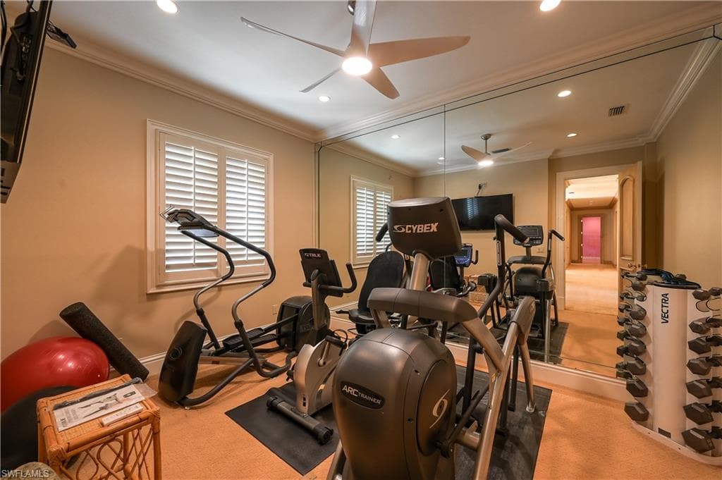 Workout area featuring ceiling fan, light colored carpet, ornamental molding, and recessed lighting