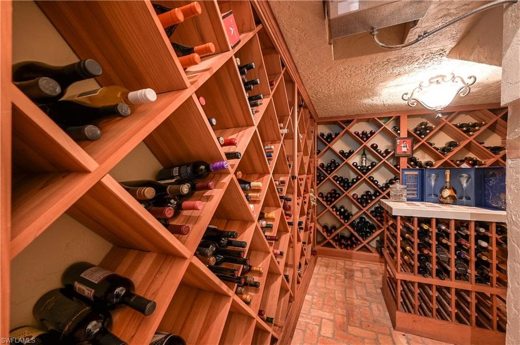 Wine room with brick floors and a textured ceiling