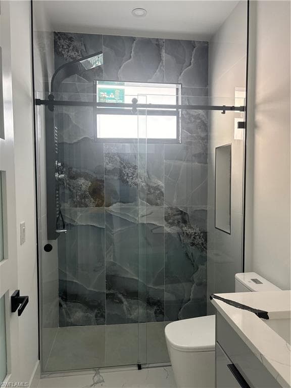 Bathroom with a marble finish shower, vanity, and marble finish flooring