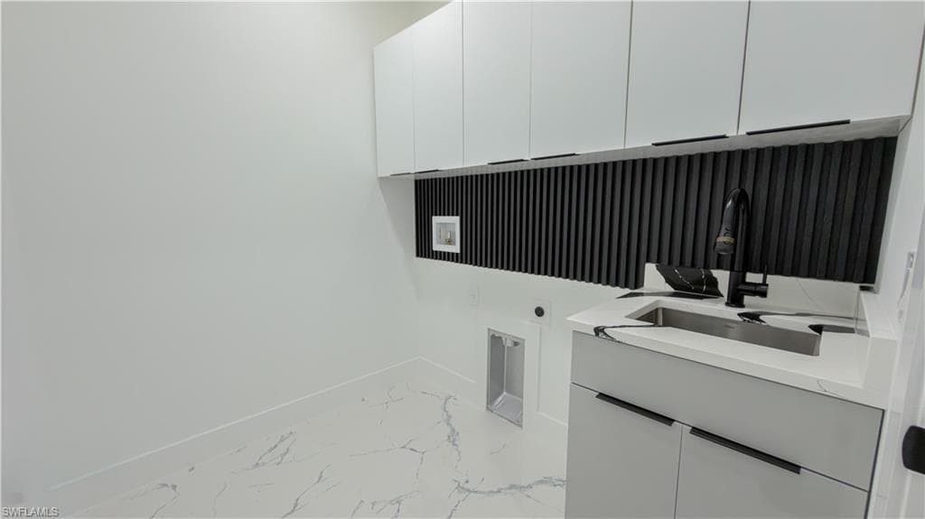 Laundry room with light marble finish floors, cabinet space, electric dryer hookup, and hookup for a washing machine