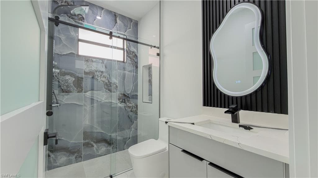 Bathroom with a marble finish shower and vanity