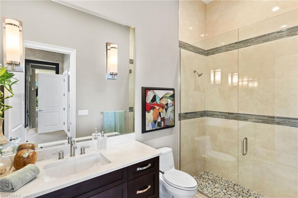 Bathroom featuring a shower stall and vanity