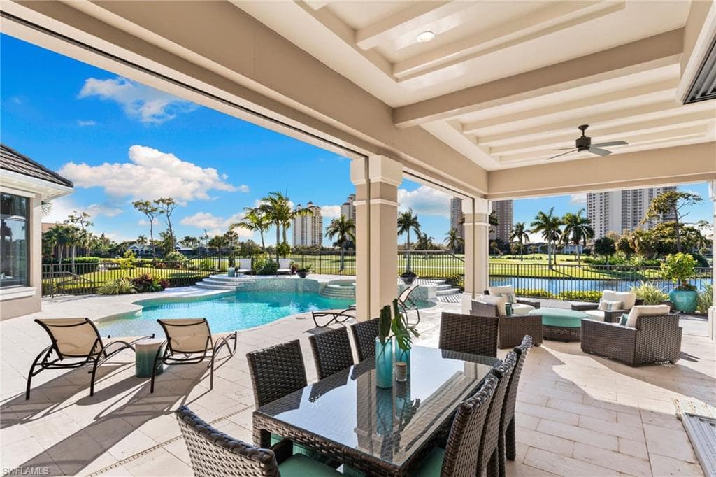 Fenced backyard featuring a patio area, an outdoor living / dining area, a pool with elevated spa, and a ceiling fan