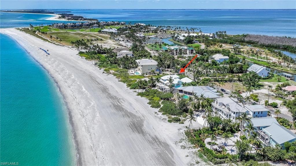 Birds eye view of property with a view of the beach and a water view