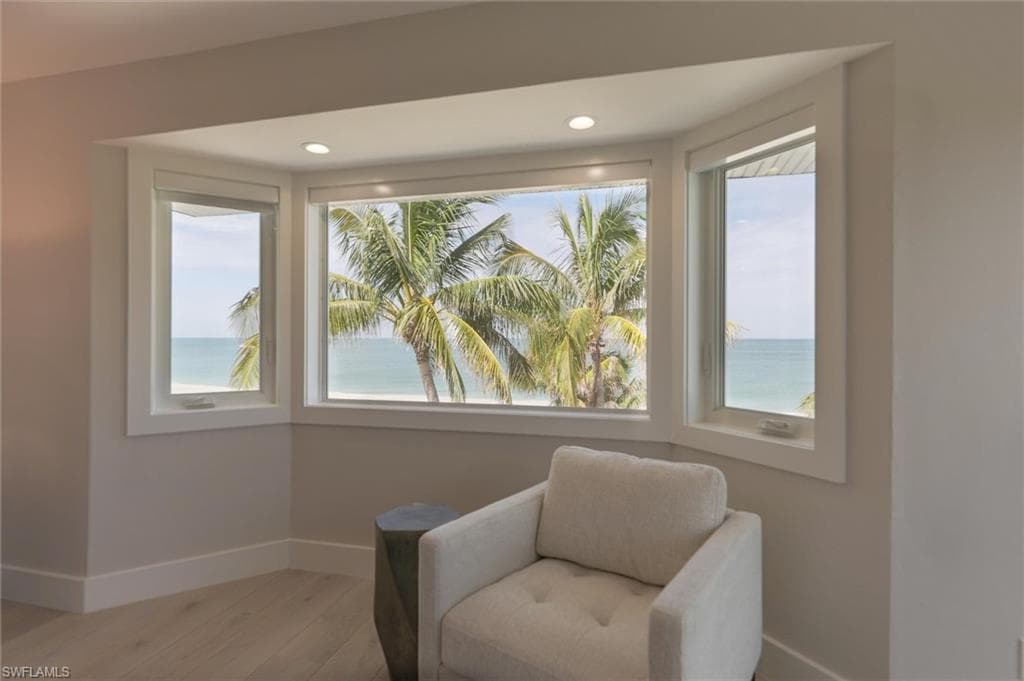 Sitting room featuring a wealth of natural light, a water view, and hardwood / wood-style floors