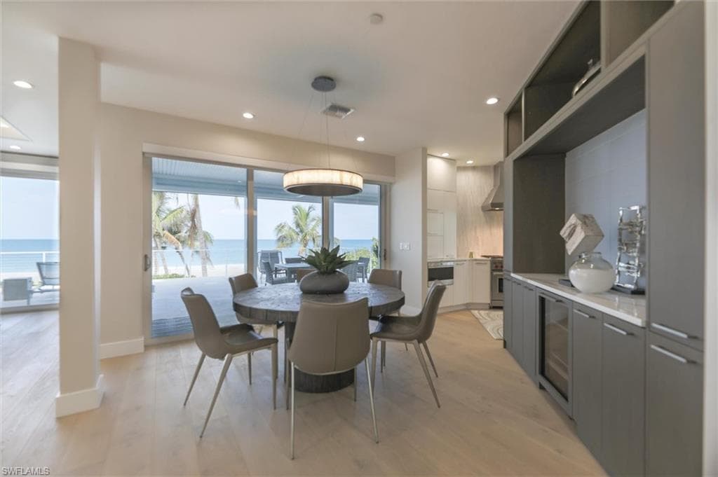Dining area featuring plenty of natural light, light wood-type flooring, and a water view