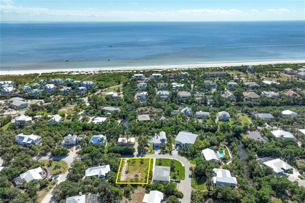 Aerial perspective of suburban area with waterfront with a beach and property boundaries highlighted