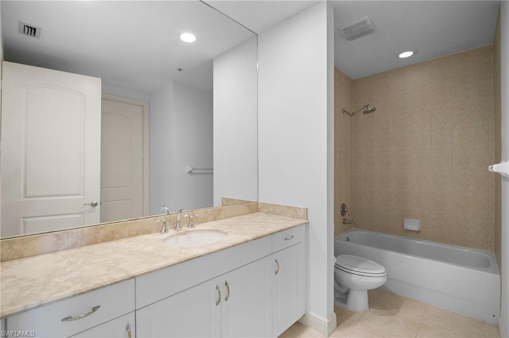 Bathroom with vanity, bathing tub / shower combination, light tile patterned floors, and recessed lighting