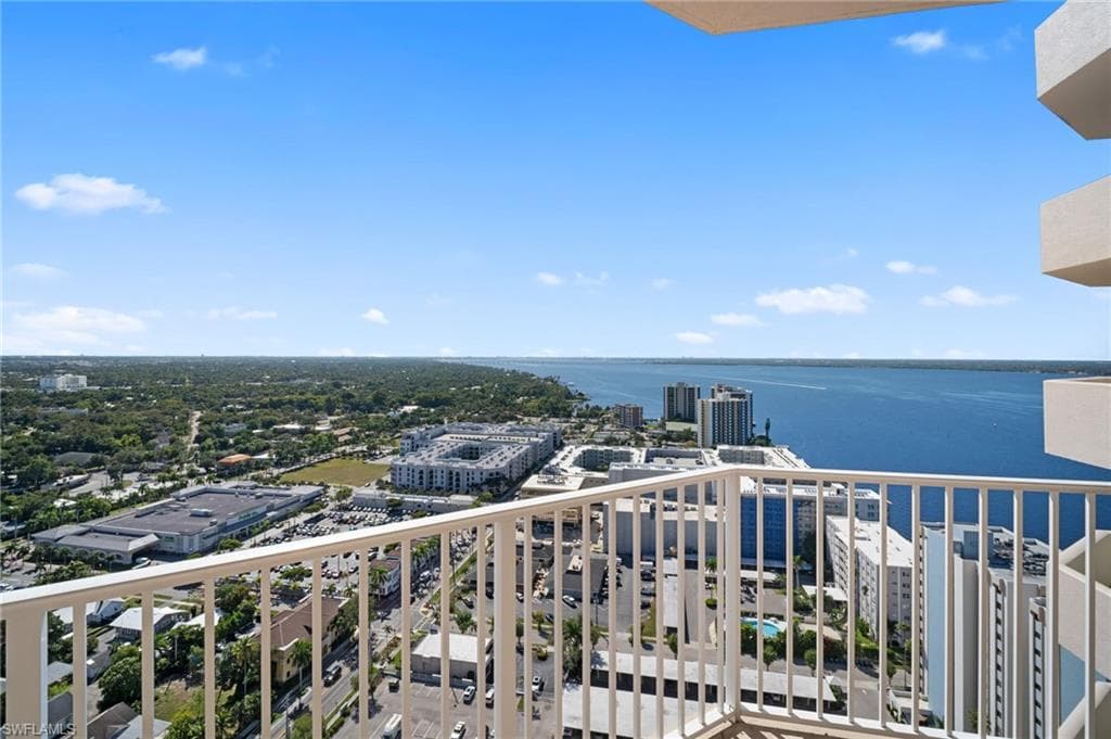 Balcony featuring a water view and a view of city