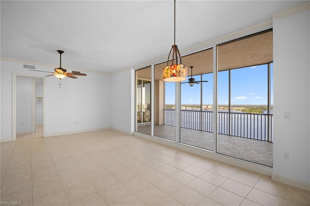 Empty room with ornamental molding, floor to ceiling windows, ceiling fan, a water view, and light tile patterned flooring