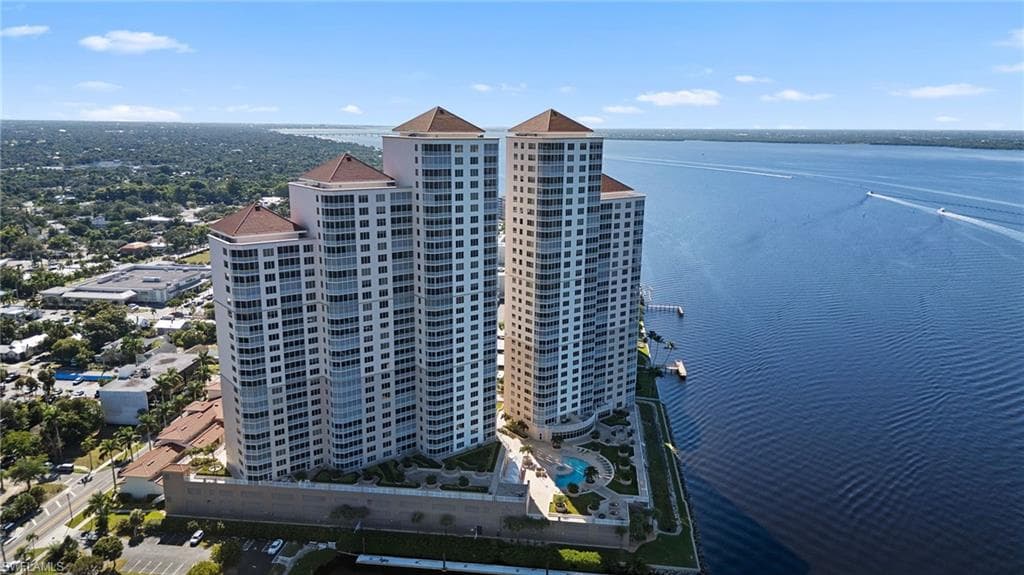 Drone / aerial view of apartment complex and a large body of water