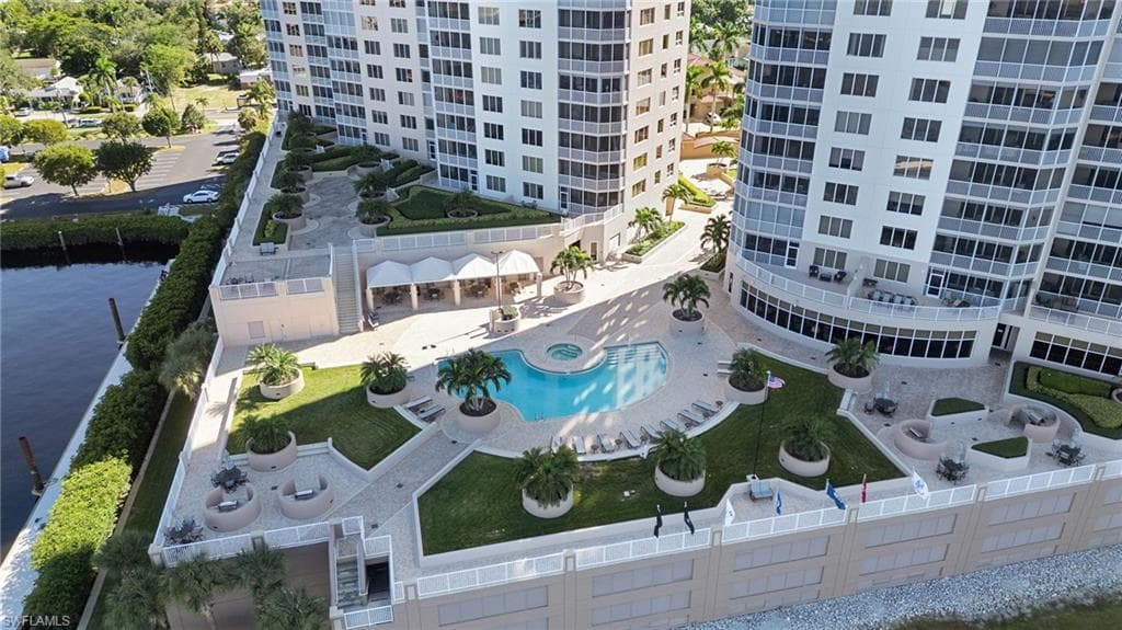 Drone / aerial view of a nearby body of water and a pool area