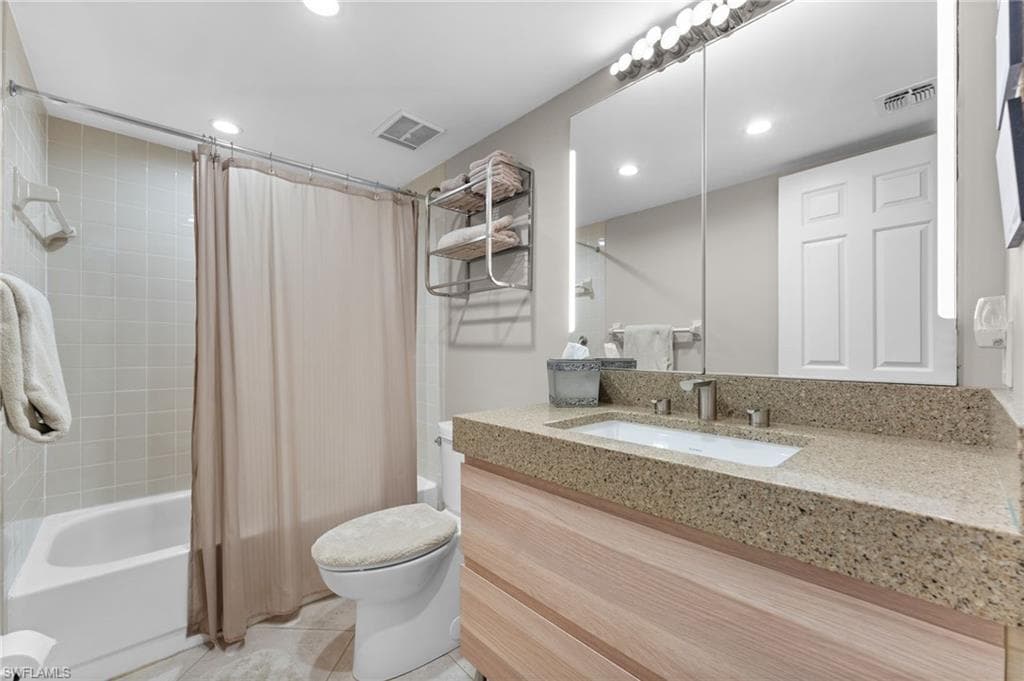 Bathroom featuring tile patterned floors, visible vents, toilet, and shower / bath combo