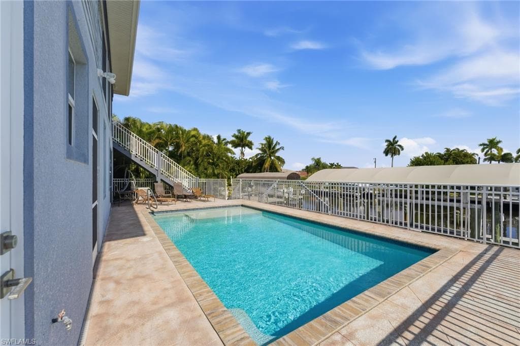 View of swimming pool featuring a patio area and stairway