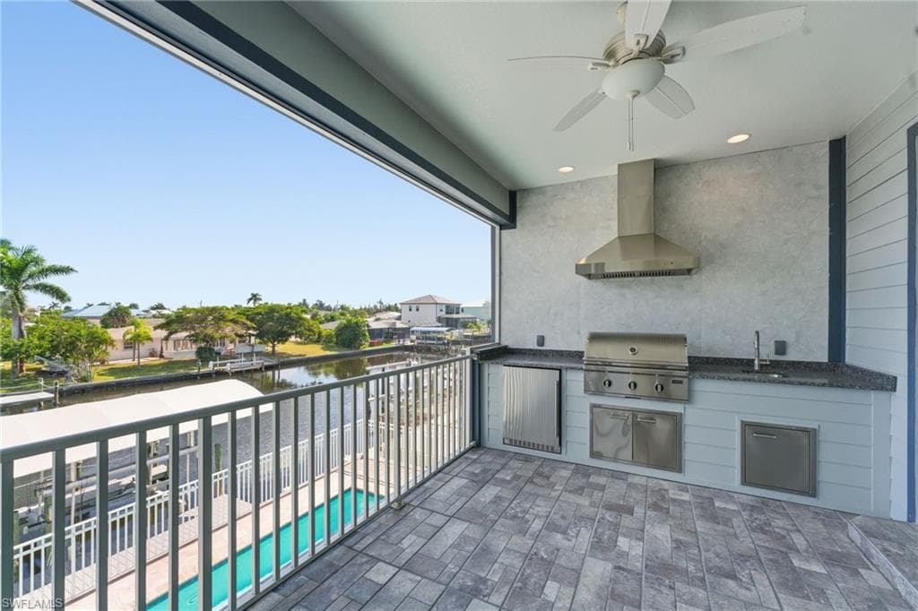 Patio / terrace featuring a ceiling fan, exterior kitchen, and a water view