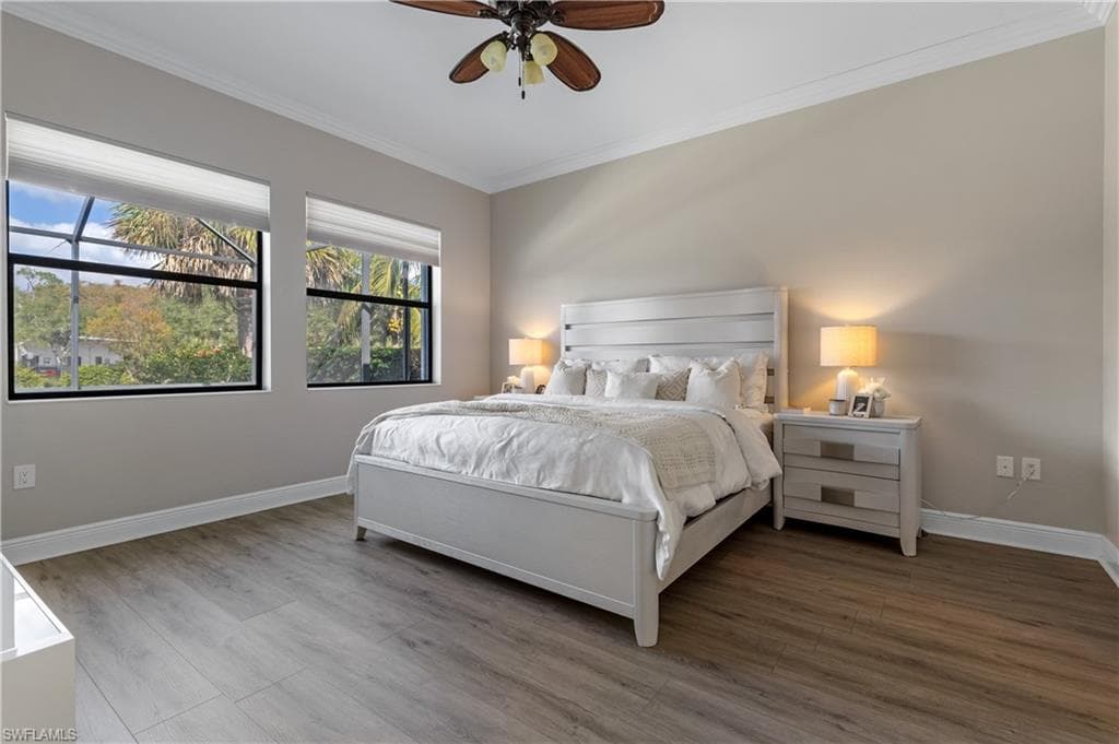 Bedroom with ornamental molding, wood finished floors, and a ceiling fan