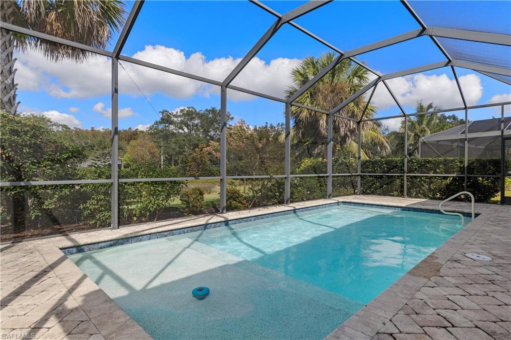 Outdoor pool featuring a lanai, a sunroom, and a patio
