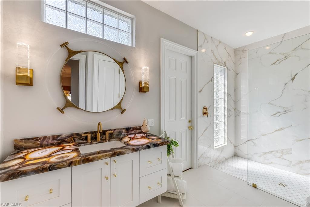 Full bathroom with vanity and a marble finish shower