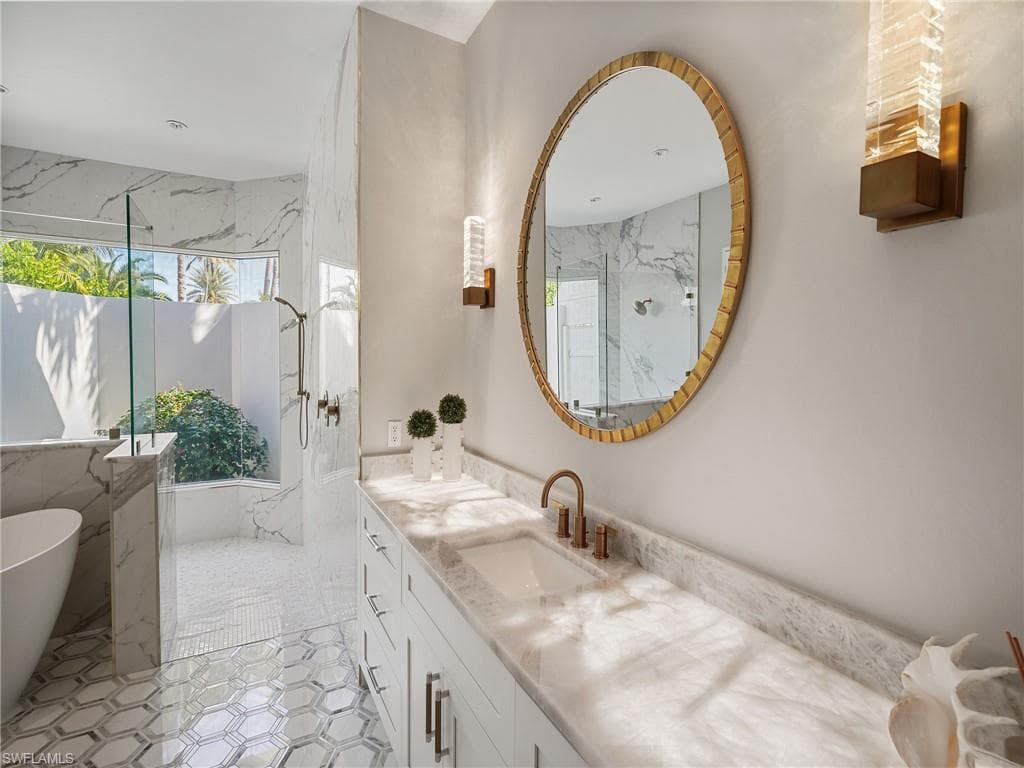 Full bathroom with vanity, a freestanding tub, and a marble finish shower