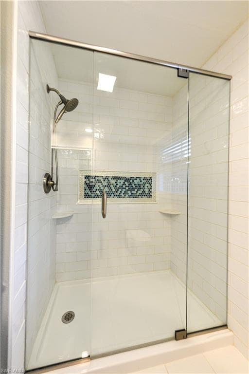 Glass and tile shower with shelves and flexible shower wand