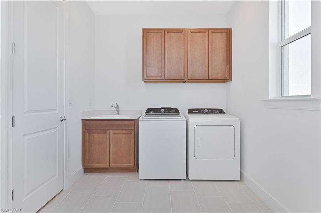 Washroom featuring plenty of natural light, cabinet space, and independent washer and dryer