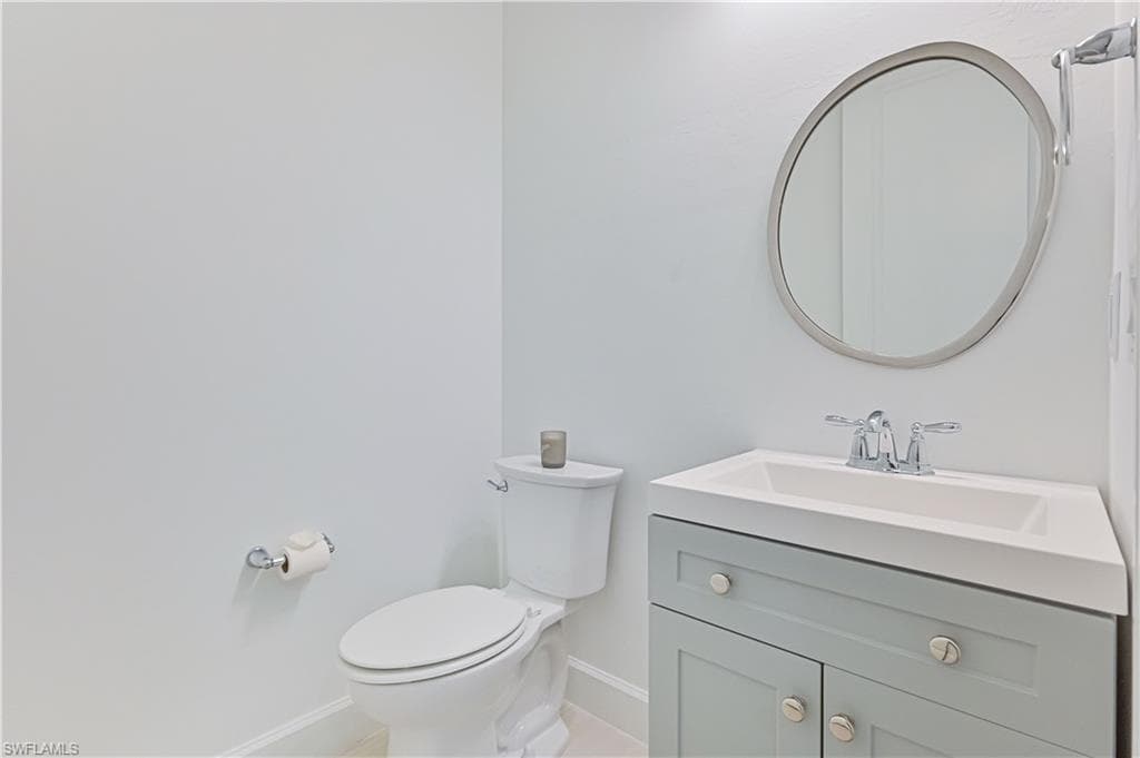 Half bathroom with vanity and toilet