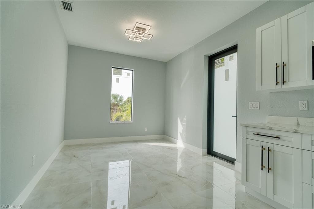 Unfurnished dining area featuring light marble finish floors