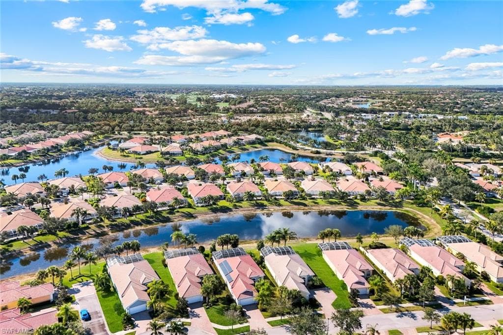 Aerial view of property and surrounding area with nearby suburban area and a large body of water