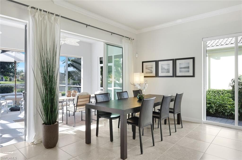 Dining space featuring ornamental molding and light tile patterned flooring