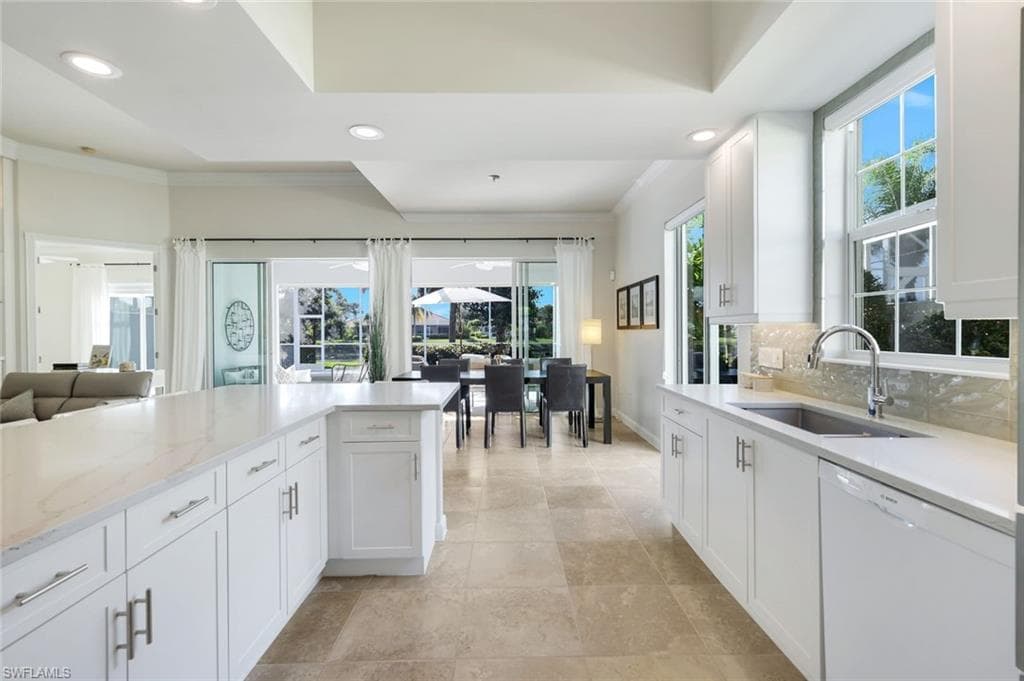 Kitchen featuring dishwasher, white cabinets, open floor plan, plenty of natural light, and recessed lighting