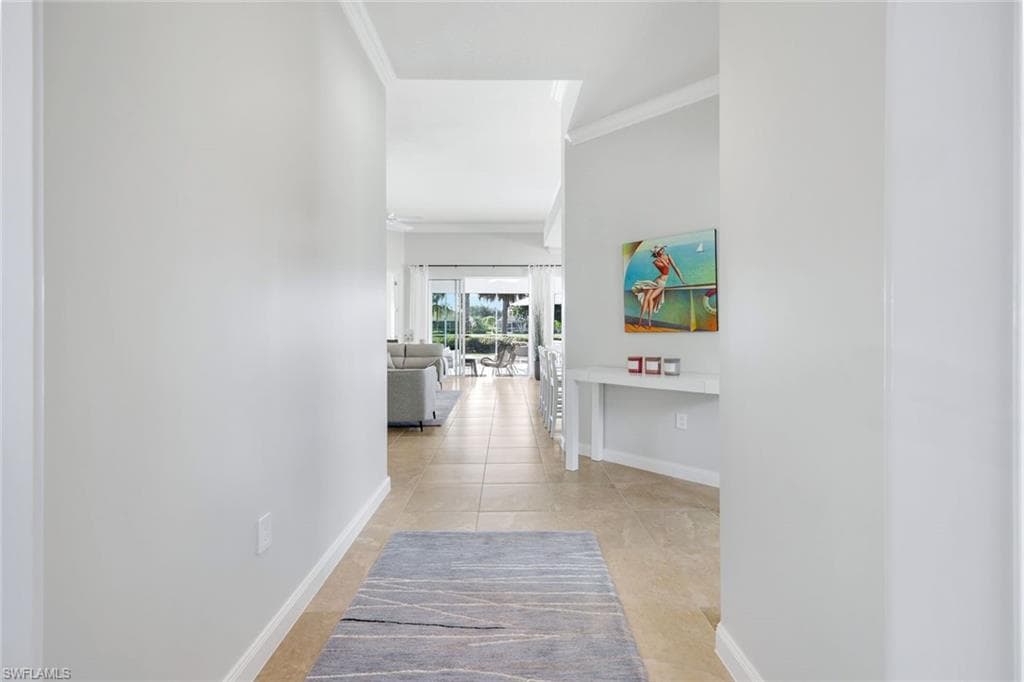 Hall with ornamental molding and light tile patterned floors