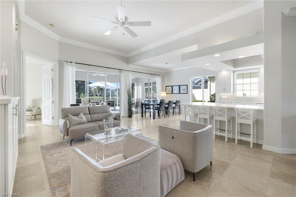 Living room with ornamental molding and a ceiling fan