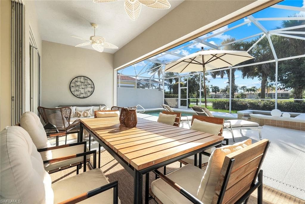 View of patio with an outdoor pool, a sunroom, an outdoor hangout area, and glass enclosure