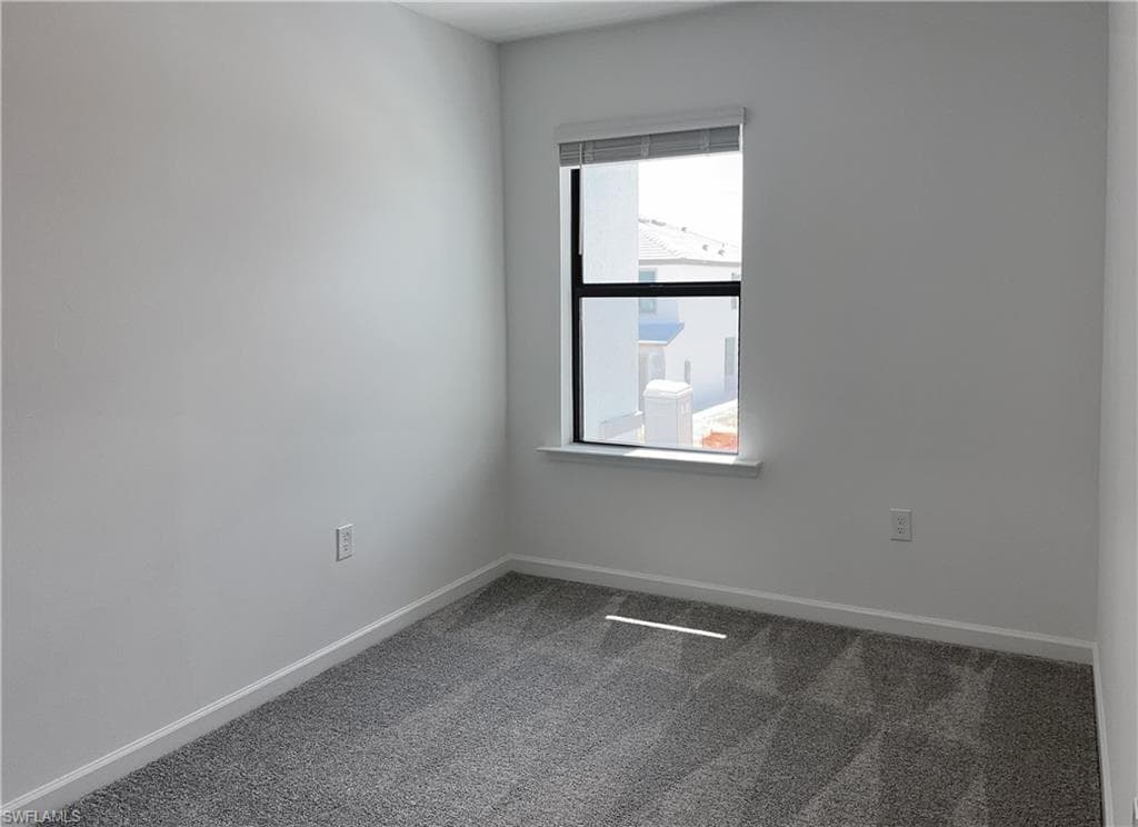 Unfurnished room with carpet flooring and baseboards