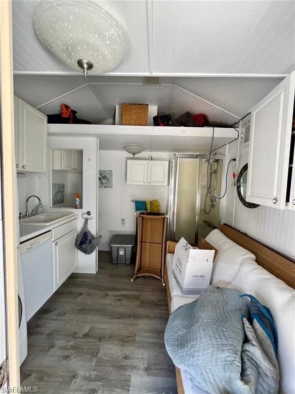 Laundry room with lofted ceiling and dark wood-style floors