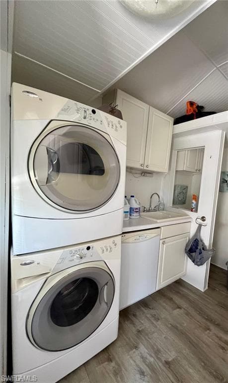 Washroom with stacked washer and clothes dryer and dark wood-style floors