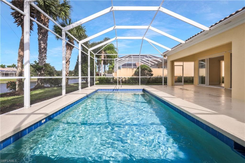 Outdoor pool with a sunroom, a patio, and glass enclosure