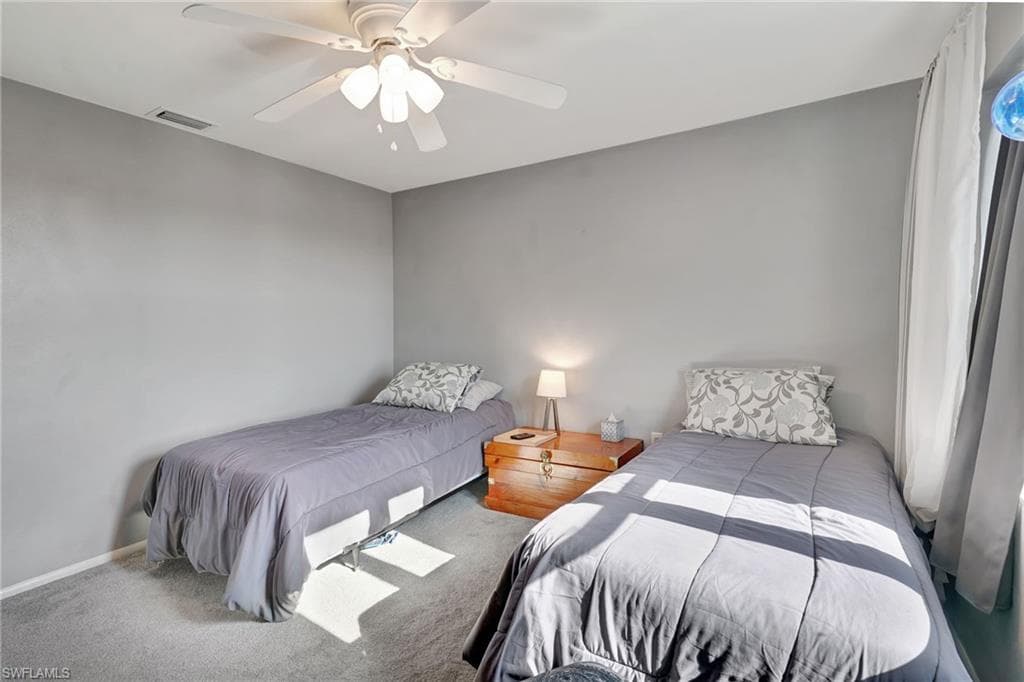 Carpeted guest bedroom with walk-in closet