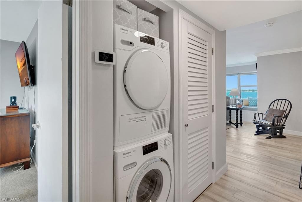 Laundry area featuring stacked washer and dryer and storage