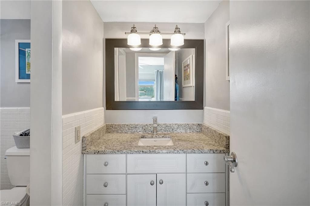 Master Bathroom with nice granite vanity, and tile walls