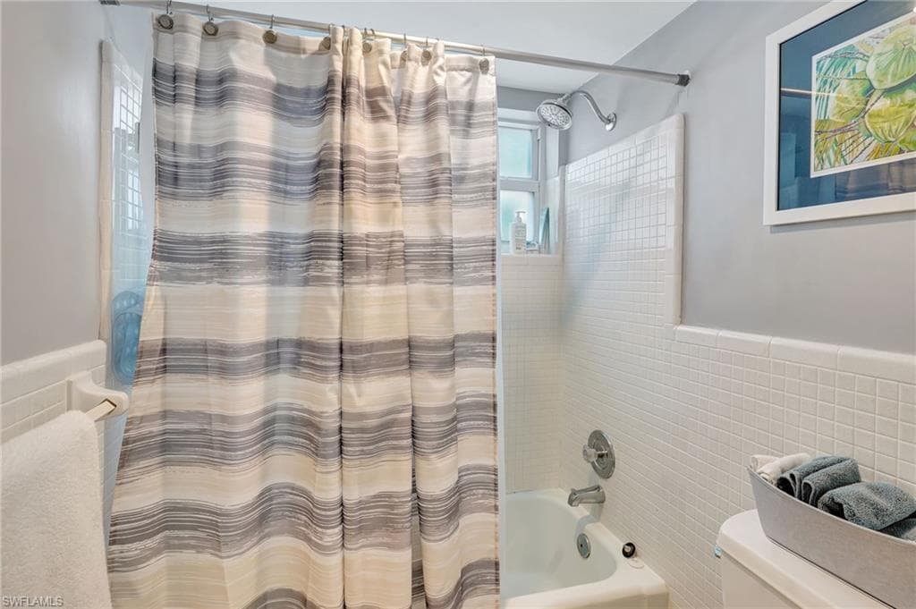 Master Bathroom with, tile walls, and shower / tub combo